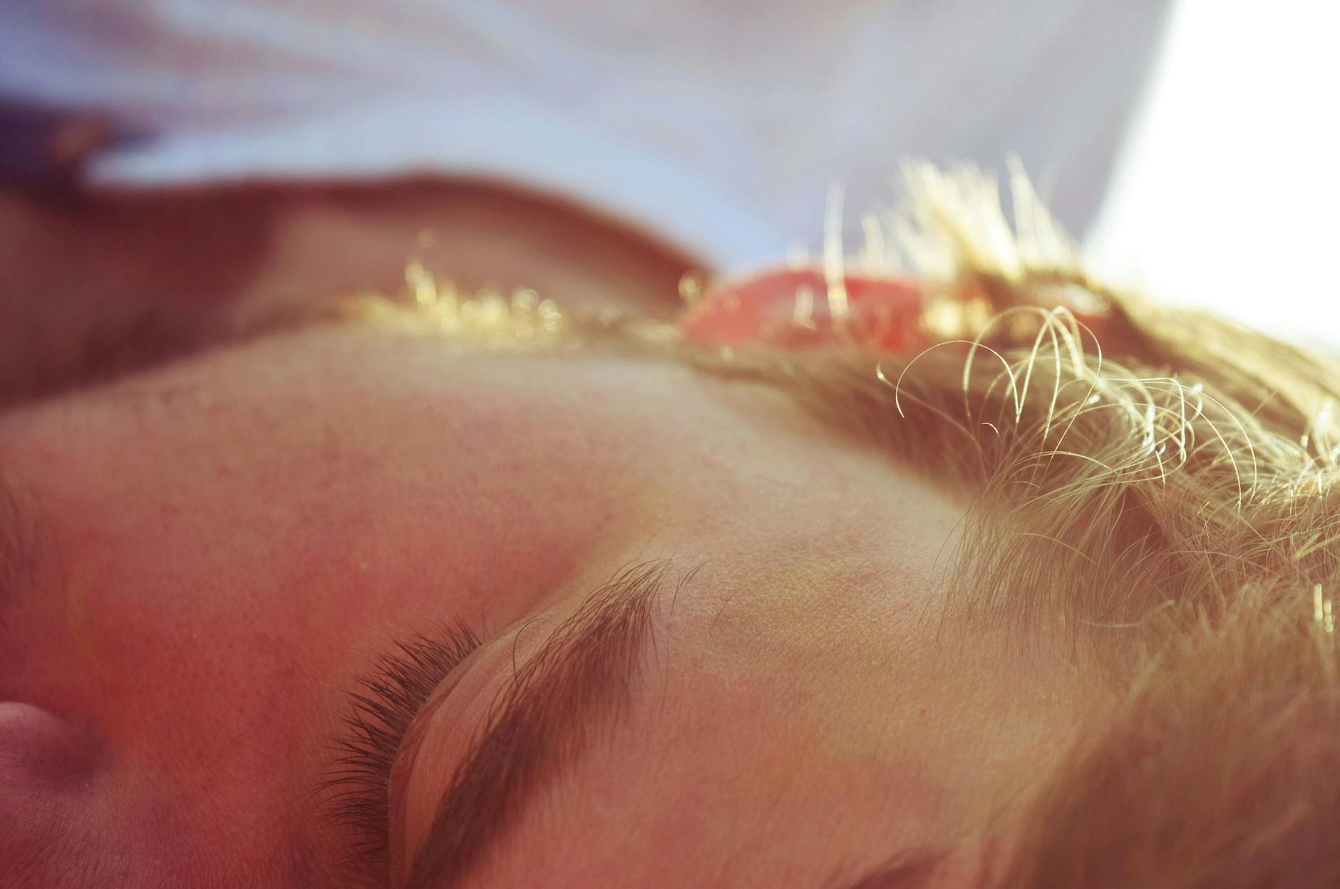 Mężczyzna spokojnie śpi w łóżku w porannym świetle