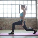 Kobieta wykonuje wykroki w salonie, ćwicząc mięśnie pośladków