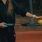 Tenisistka przygotowująca się do uderzenia na ceglastym korcie