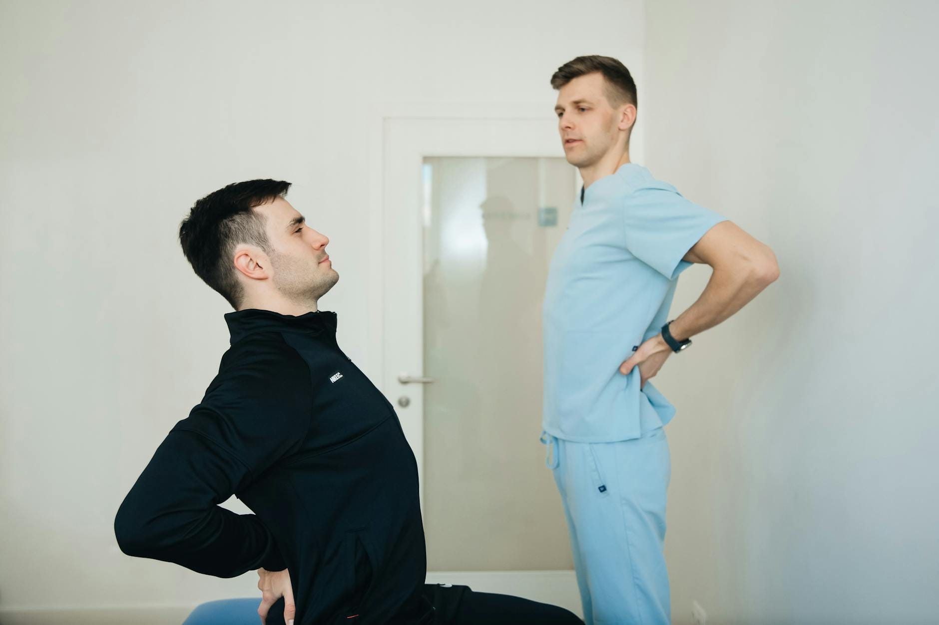 Fizjoterapeuta pokazuje pacjentce ćwiczenia wzmacniające plecy w gabinecie