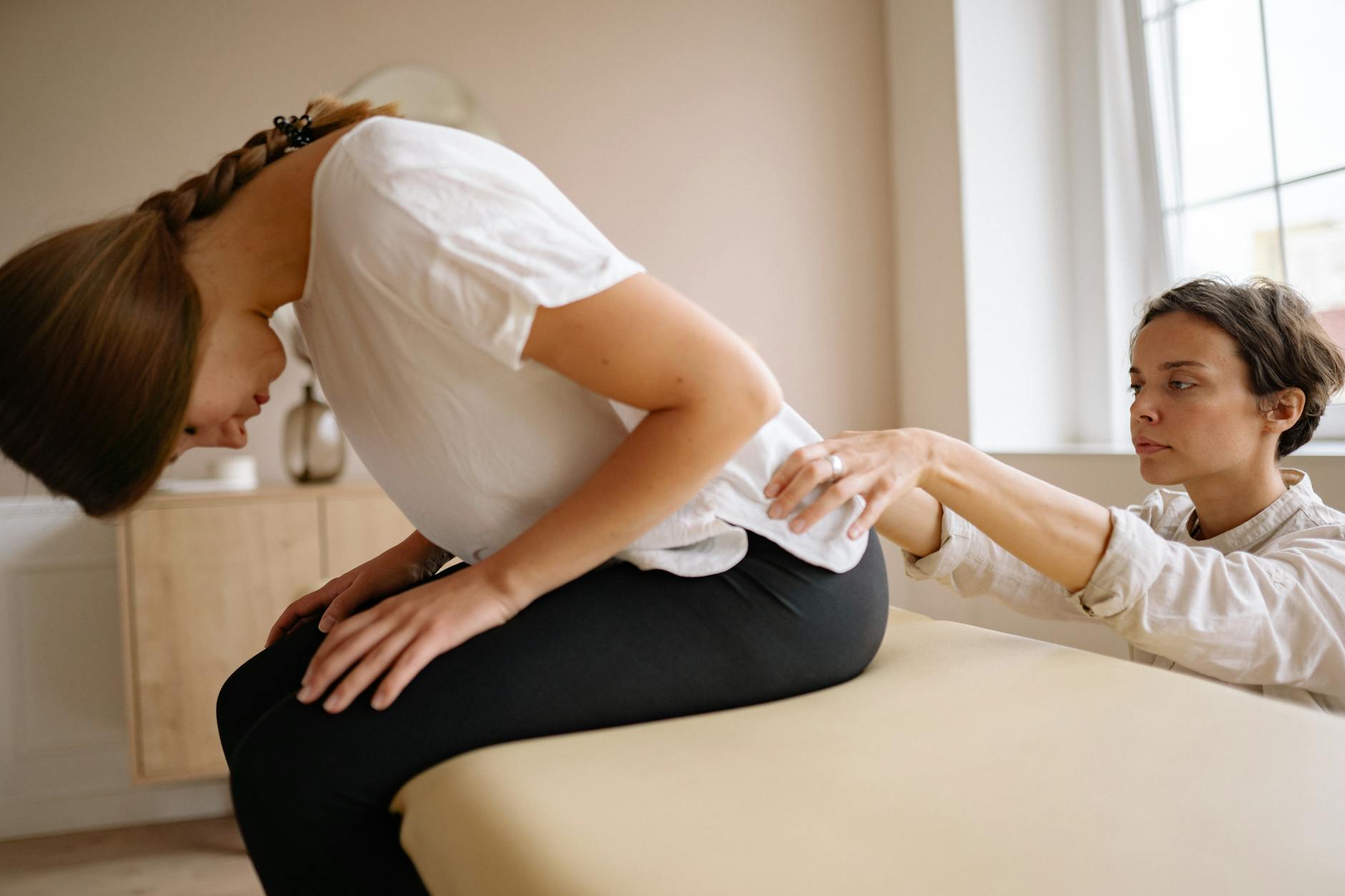 Fizjoterapeuta rozciąga plecy pacjenta podczas terapii kręgosłupa