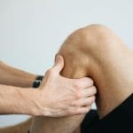 Rehabilitacja po meniscektomii: tempo powrotu do biegania Fizjoterapeuta wykonuje masaż kolana pacjenta po zabiegu menisku