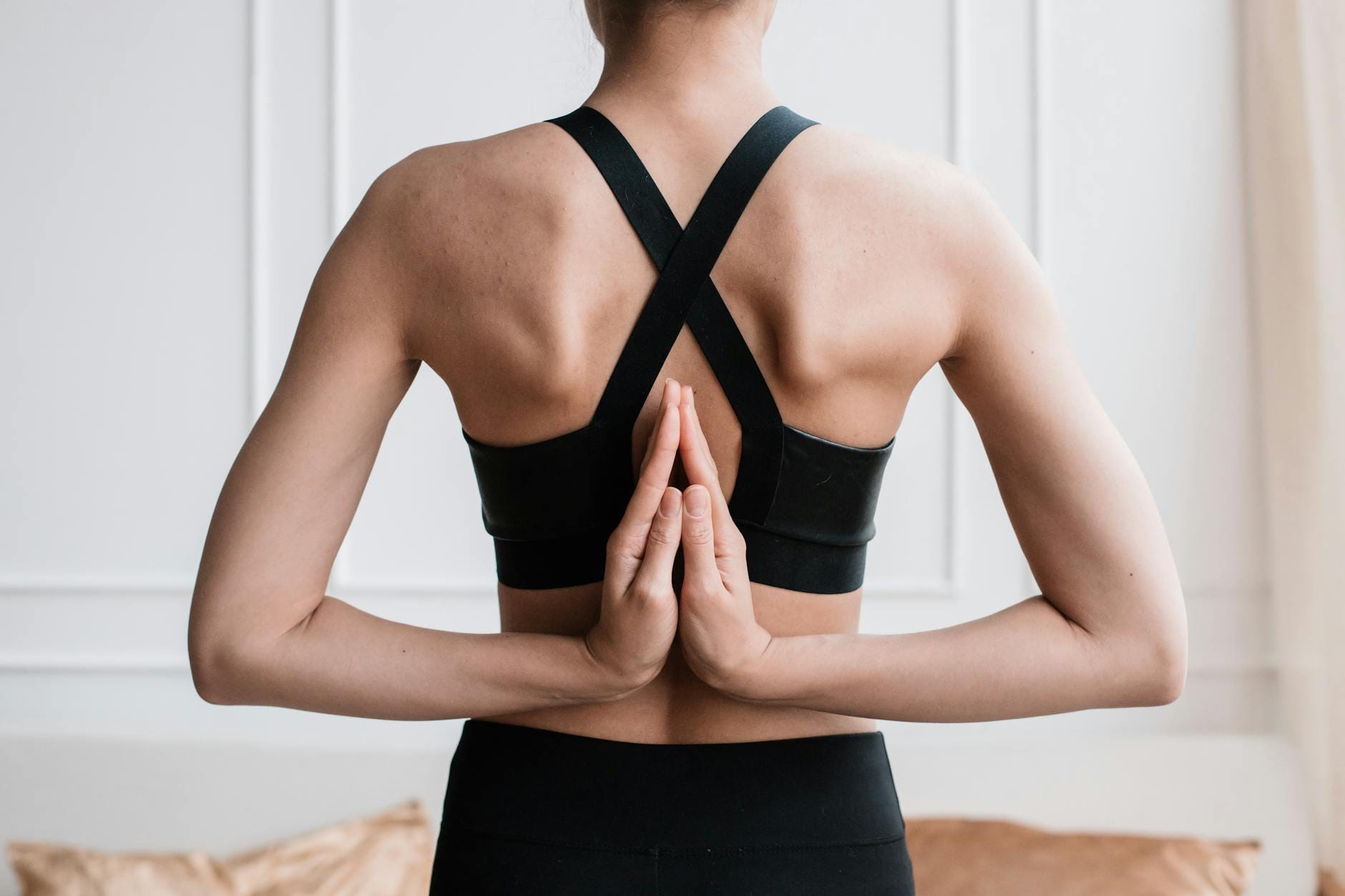 Kobieta w pozycji paschima namaskarasana na zajęciach jogi w sali