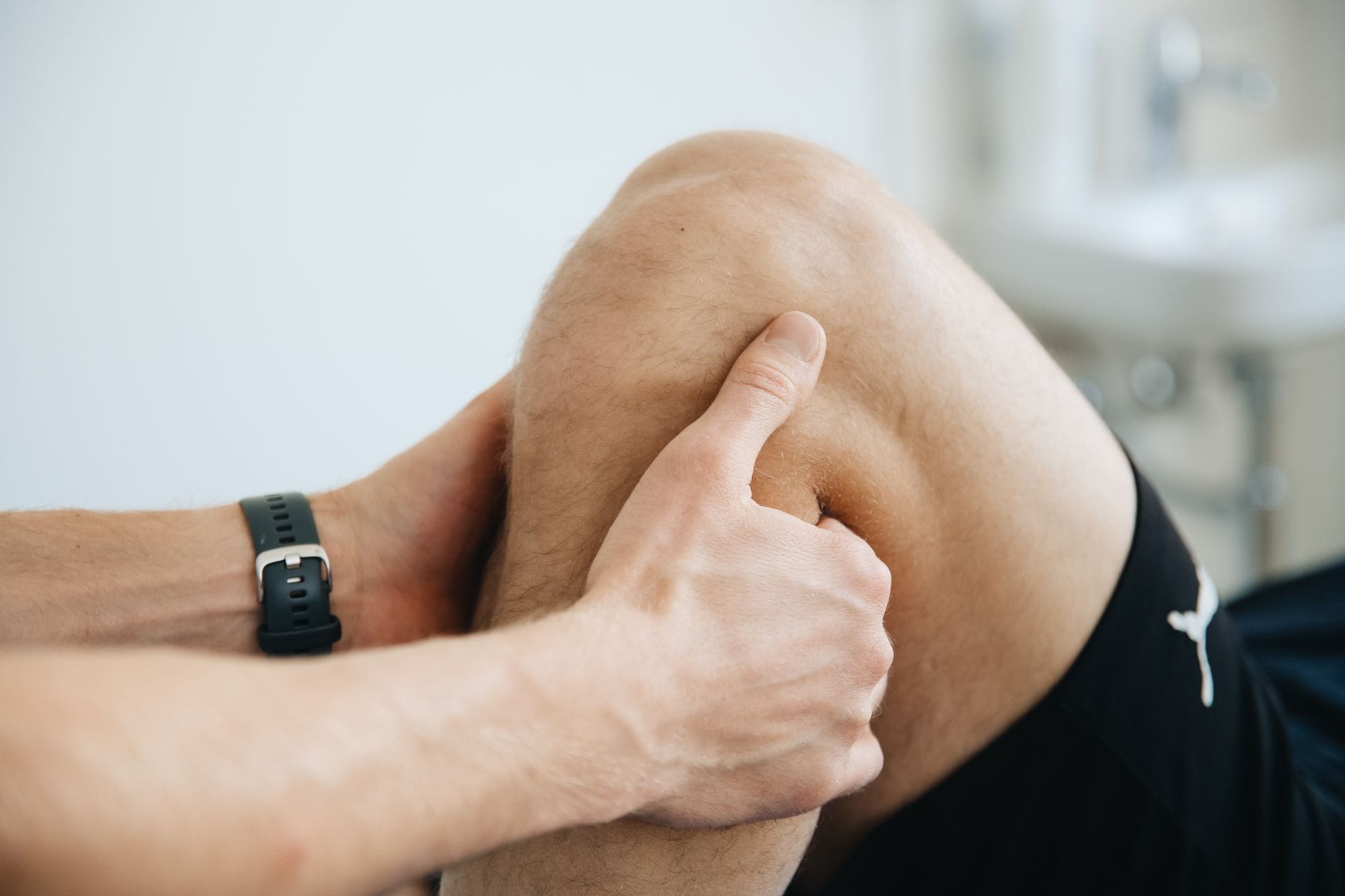 Rehabilitacja po endoprotezie kolana: plan ćwiczeń i sygnały alarmowe Fizjoterapeuta masujący kolano pacjenta podczas rehabilitacji